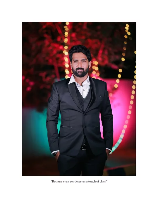 Editorial groom portrait in black suit with colourful lights