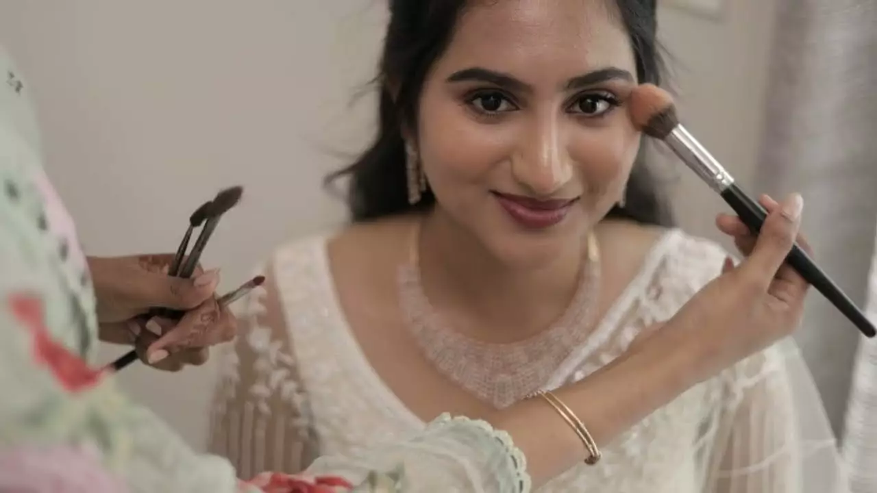 Candid bridal makeup moment captured by candid wedding photographer in Valliyur